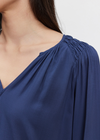 Velvet Azalea Blouse.The Azalea Blouse is crafted from rayon challis for a soft and lightweight feel. It includes a v-neckline, smocked shoulder detail, elastic ruffle cuffs, and a scooped hemline. Its slight sheen and draped fit make it a versatile choice for any wardrobe.