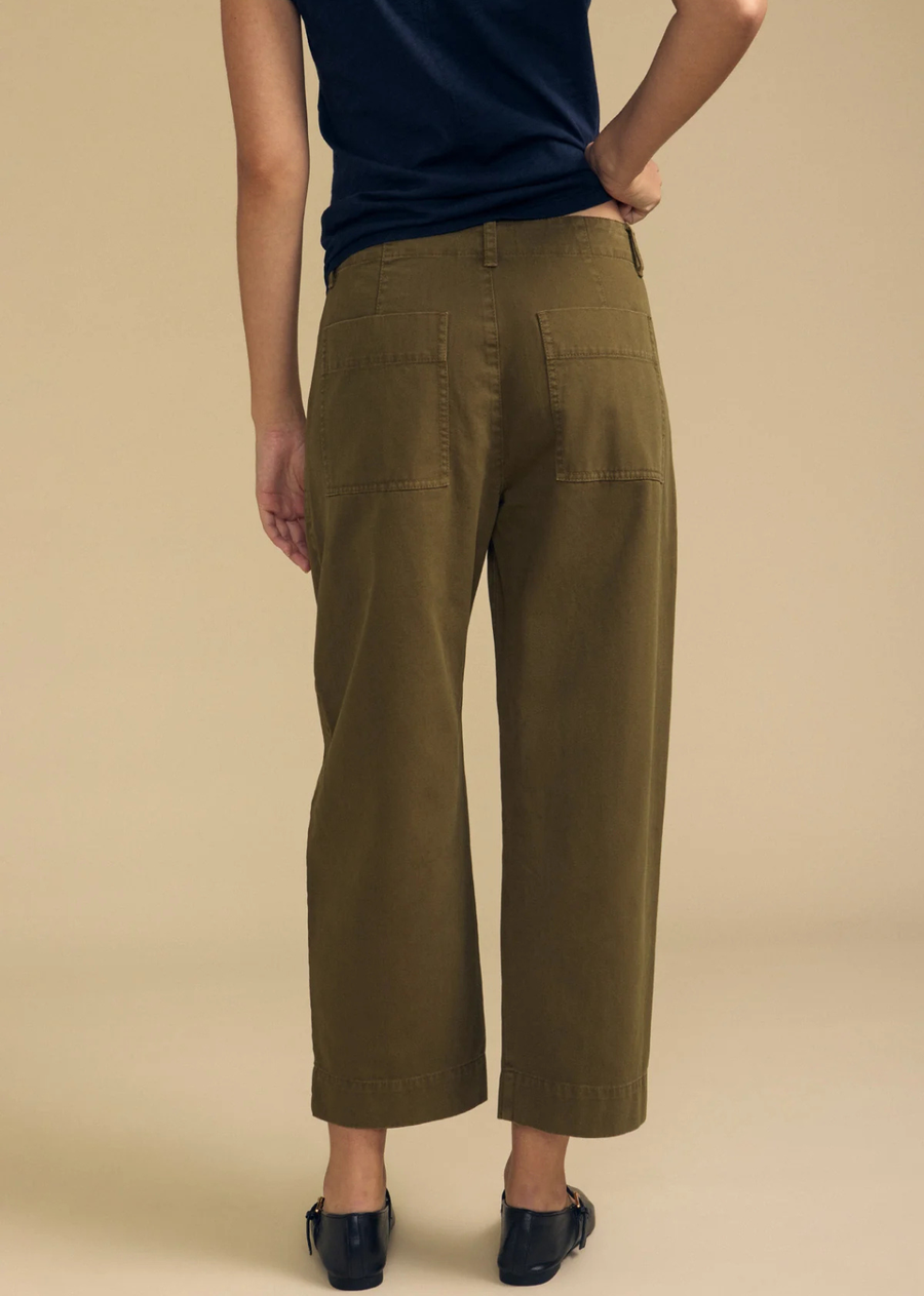 With a tailored fit and cropped ankle, this pant offers a modern silhouette enhanced by darting detail at the knee and practical slash and rear patch pockets. Featuring a zipper and button closure with belt loops, they combine style and functionality effortlessly. A versatile essential that brings polished ease to any outfit.
