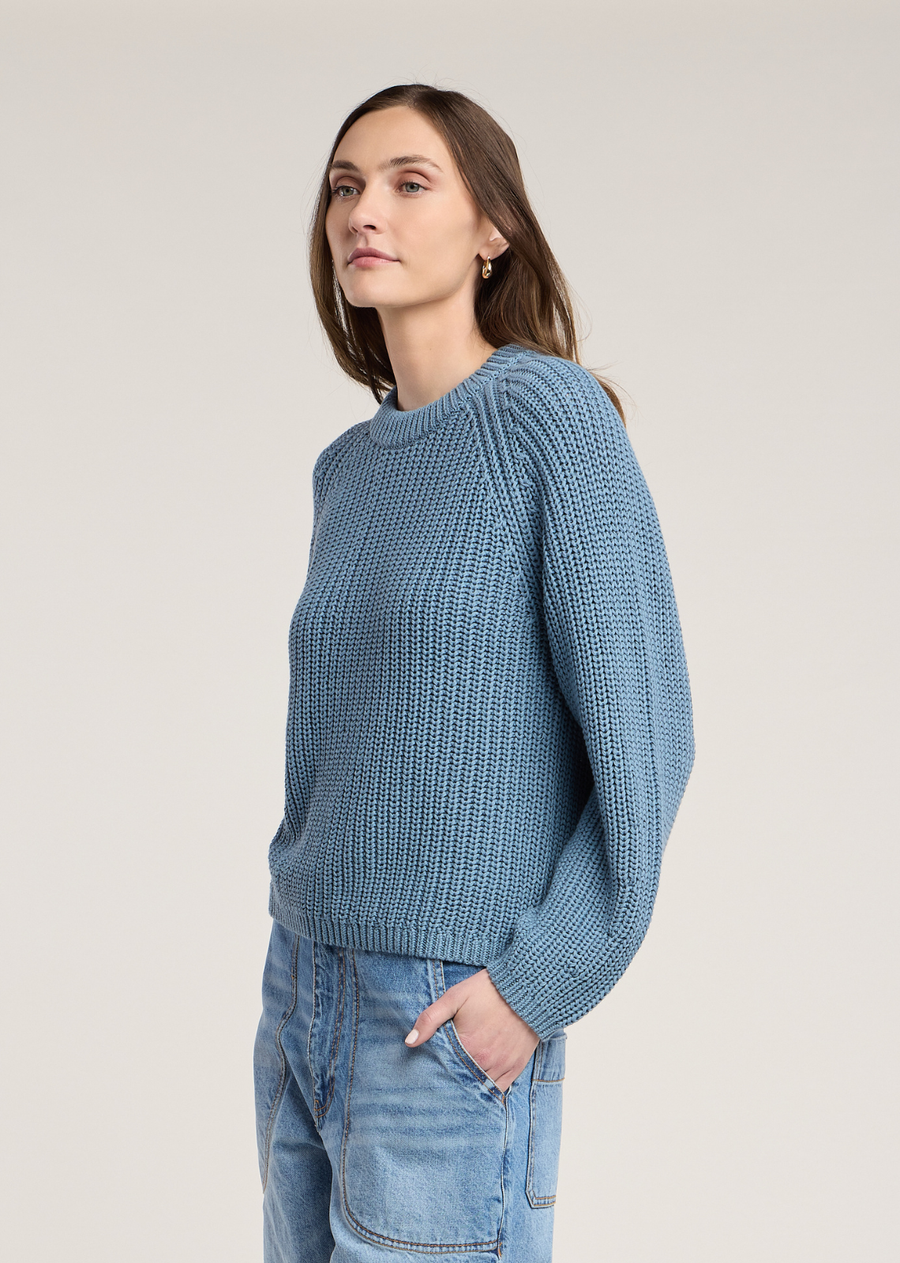 This cozy long-sleeve sweater is knit from premium chunky pima cotton in a serene, dusty cornflower blue shade. Featuring a textured rib stitch, the design offers a soft, chunky feel with an effortlessly relaxed fit.