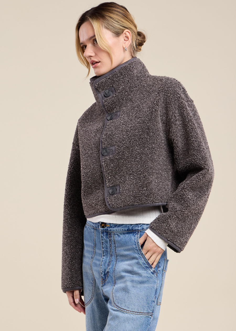 A cropped take on our Shona jacket, the Esme is a reversible design offering two looks in one—plush faux sherpa on one side, smooth faux suede on the other. It features a button-front closure and mock neckline for a polished, structured finish. The dual fabrication gives you the flexibility to switch up your look without switching your jacket. Wear it either way over knits and denim for effortless, cold-weather layering.
