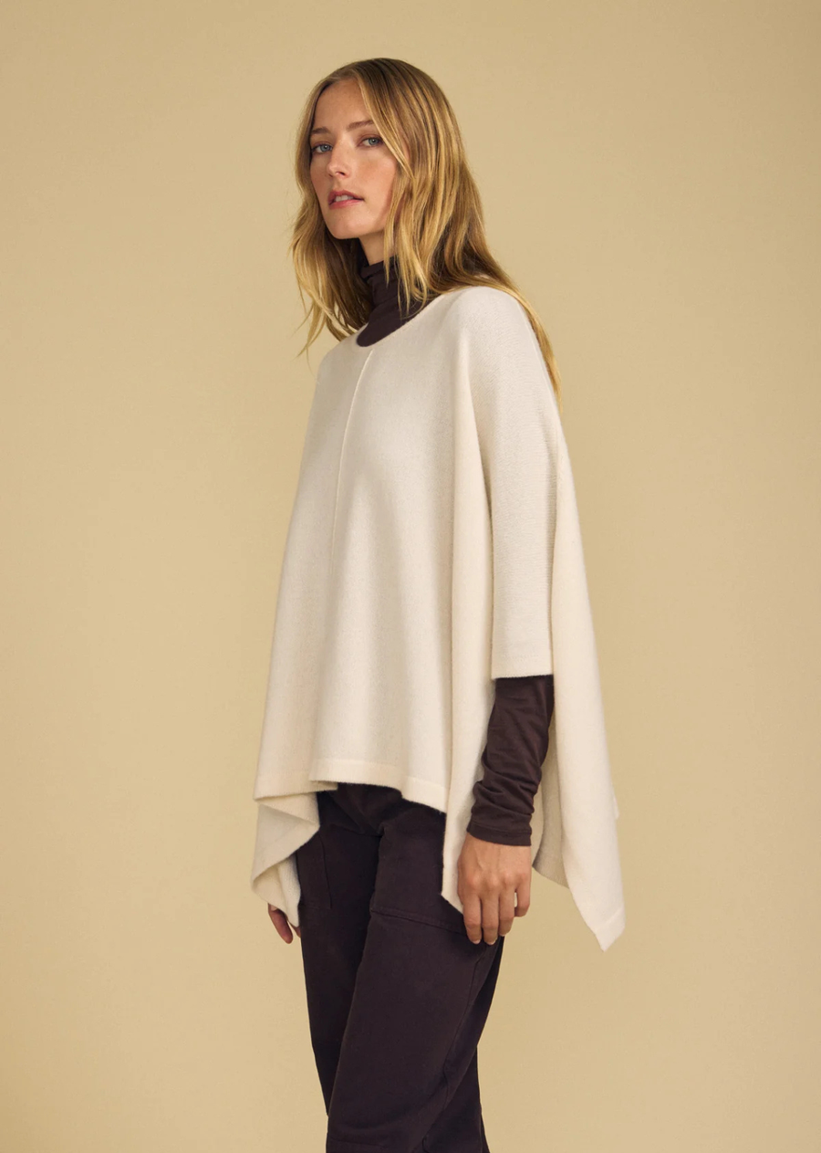 Effortlessly cozy, the Gia is a merino wool blend poncho designed for easy, drapey layering. It features a round neckline and a relaxed, flowing silhouette that falls beautifully over the body. The soft wool blend offers warmth without bulk, making it simple to throw over a long sleeve tee for instant polish. A one-and-done layering piece for cooler days.