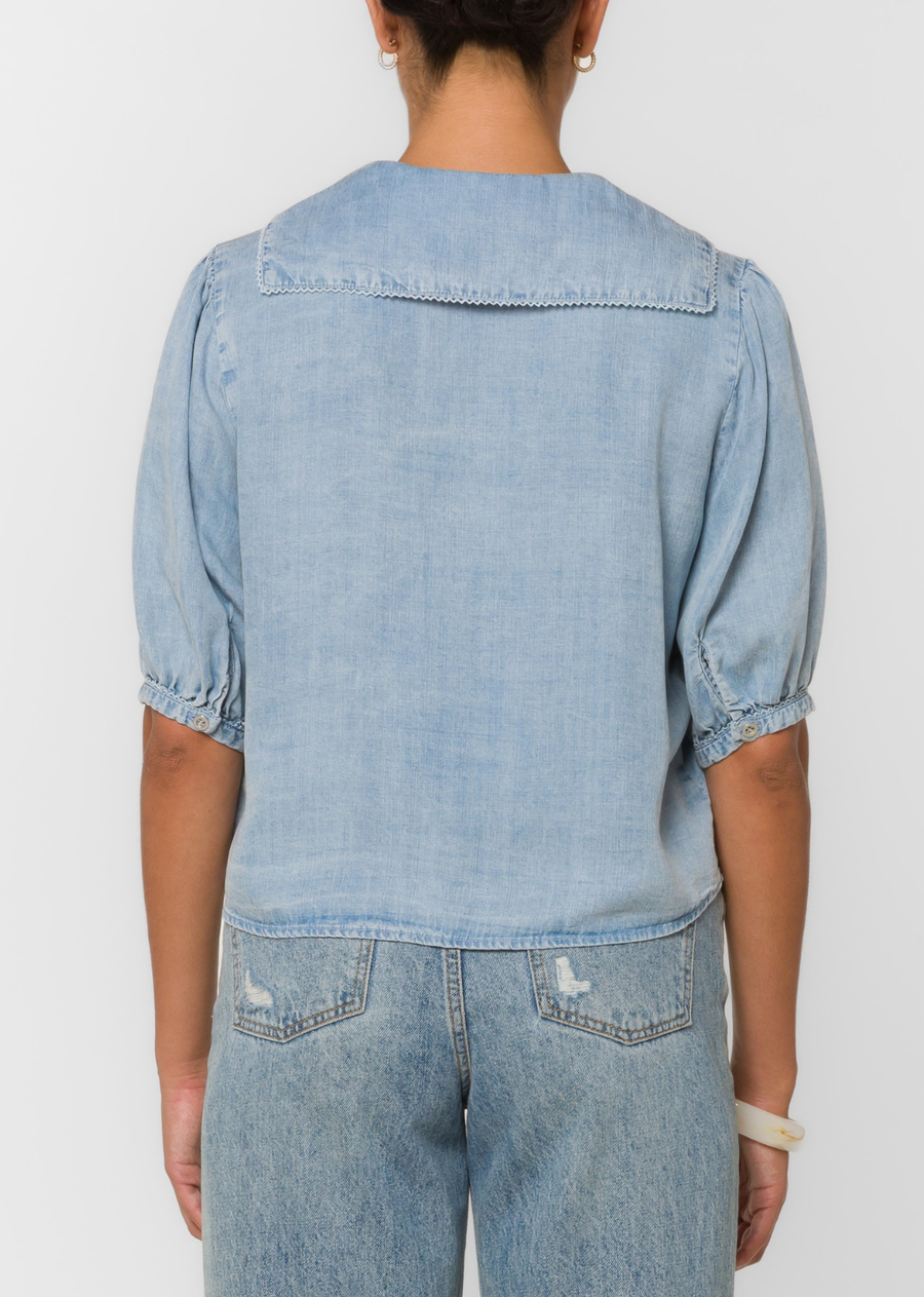 This drapey denim-look blouse features puff sleeves, a feminine tie neckline, Peter Pan collar for a lightweight feel and effortless movement.
