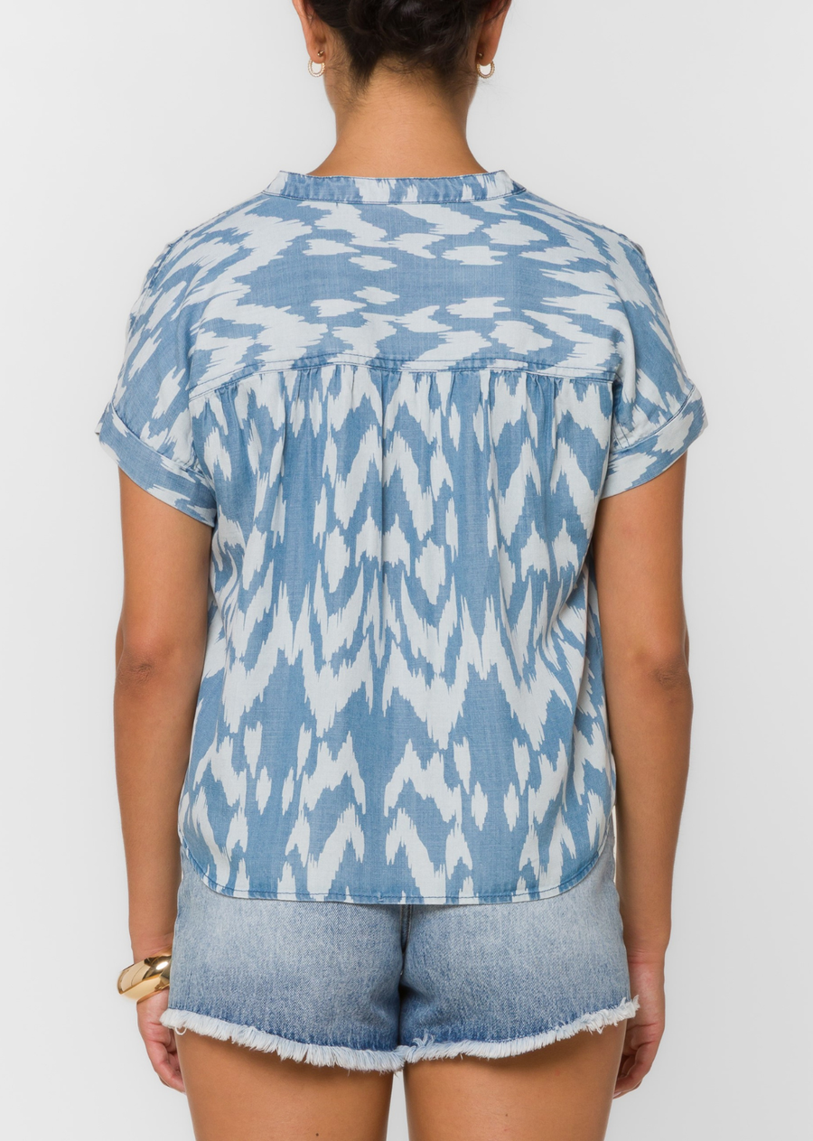 Effortlessly chic with a touch of coastal charm, this printed blouse is an easy addition to your warm-weather wardrobe. Featuring a soft blue and white abstract print, it is designed with a split neckline, a relaxed silhouette, and rolled short sleeves for an effortlessly polished look.