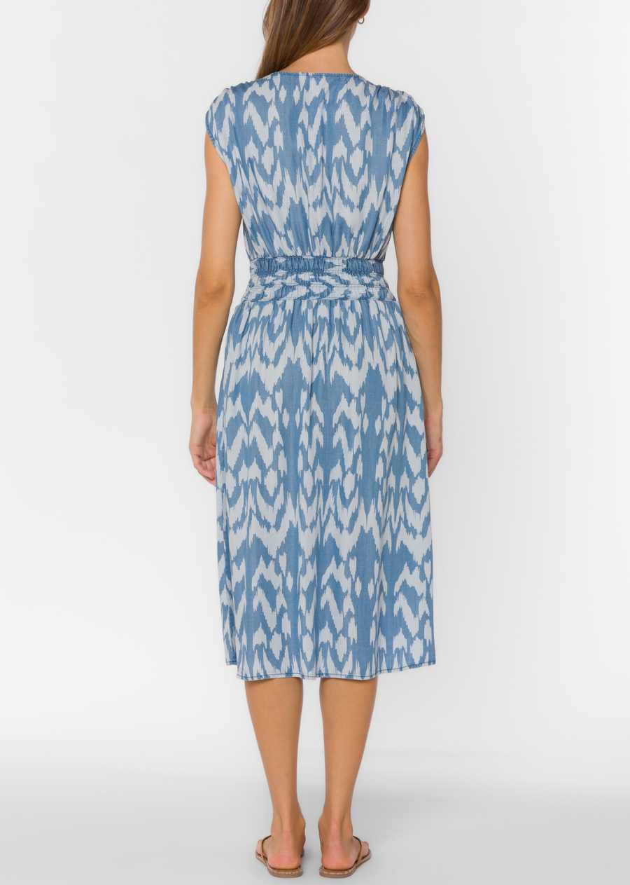 This sleeveless midi dress features a flattering V-neck, stretchy smocked waist, side pockets, and a lightweight, fluid feel.