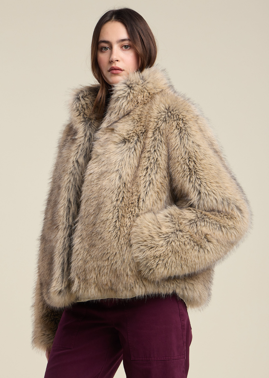This plush faux fur jacket is featured in a warm taupe shade with soft, multi-tonal tipping that adds depth and dimensional texture throughout. Designed with a boxy, slightly cropped silhouette, it features a high stand collar for extra warmth and a sleek front closure that lets the luxurious texture take center stage. Full-length sleeves drape loosely to the wrists, offering an invitingly cozy feel.