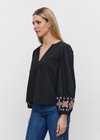 Velvet Paola Embroidered Top. This cotton top features a v-neckline and relaxed fit. The raglan sleeves add a hint of laid-back flair, while the vibrant floral embroidery adds a whimsical charm to your ensemble.