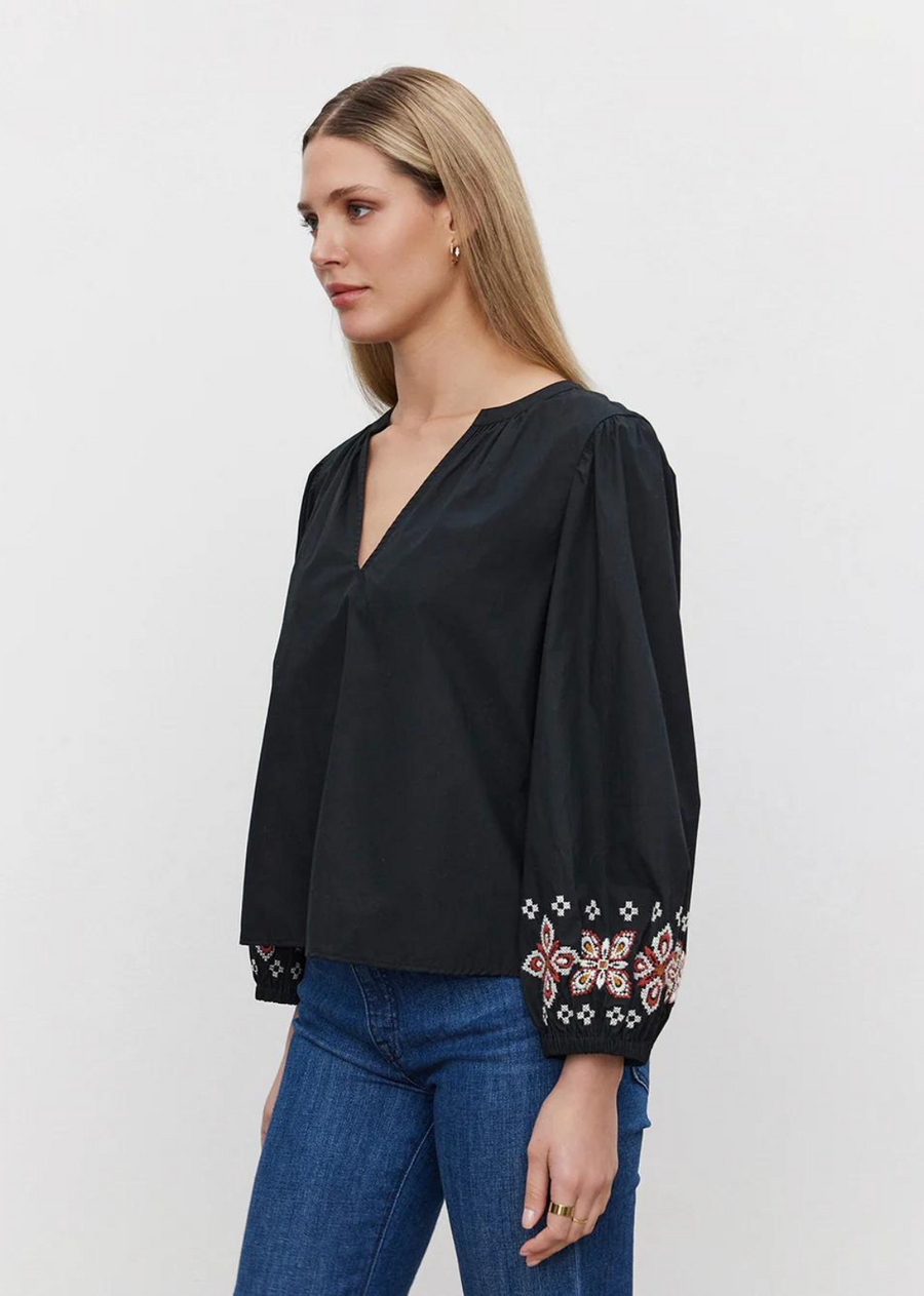 Velvet Paola Embroidered Top. This cotton top features a v-neckline and relaxed fit. The raglan sleeves add a hint of laid-back flair, while the vibrant floral embroidery adds a whimsical charm to your ensemble.