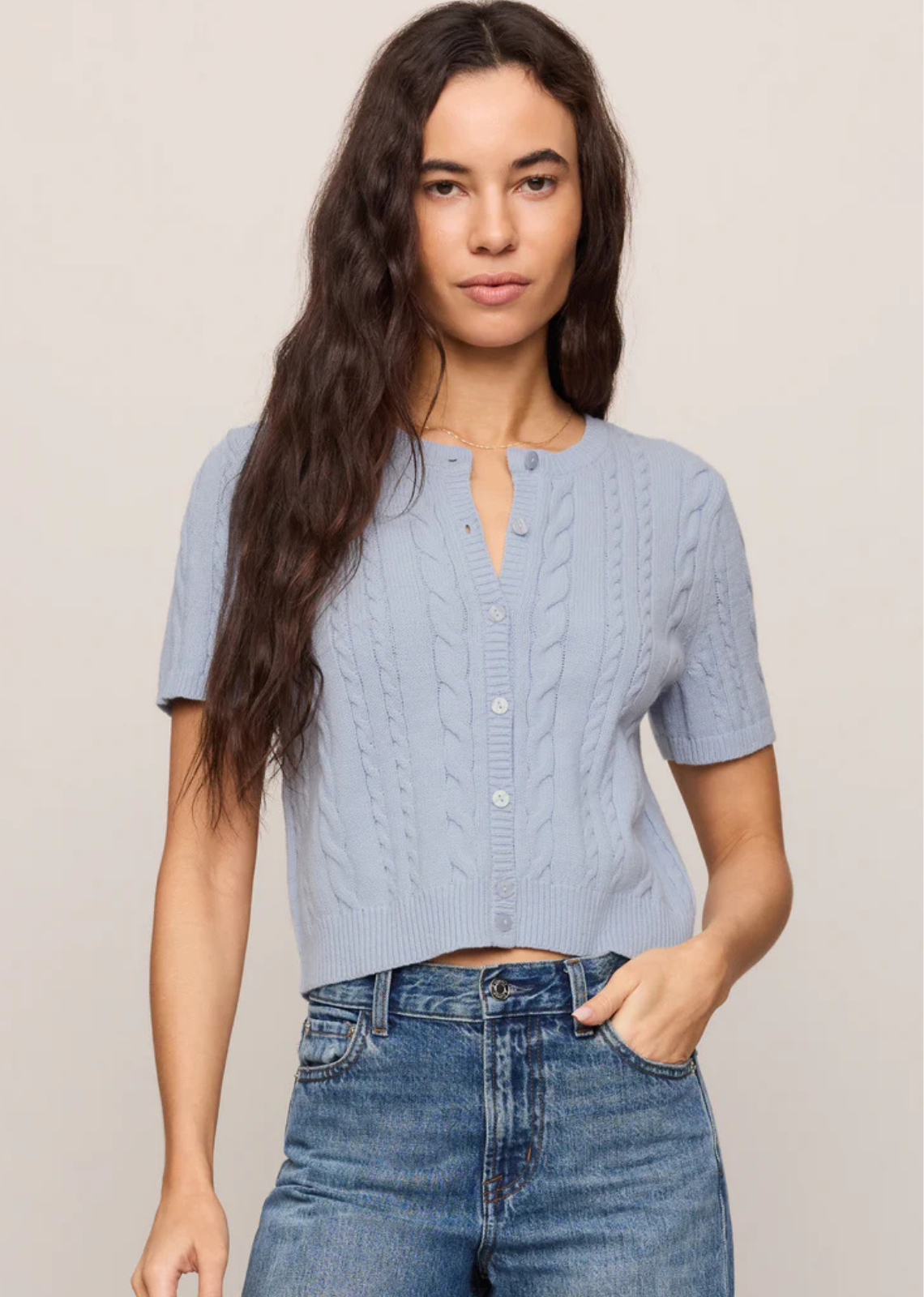A short sleeve cardigan with cable knit detail and a soft structure.
