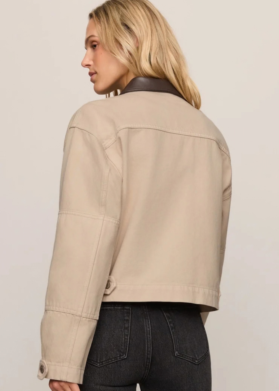 Some jackets do more than finish an outfit. This one helps create it. Designed in 100% cotton Modern Vintage Denim with a faux leather collar, oversized utility pockets, and pleated cuff details, it blends workwear inspiration with a cropped silhouette that feels right at home in a modern wardrobe.