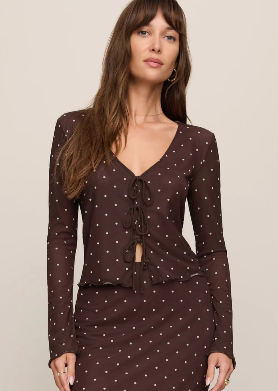 Made from lightweight stretch mesh with a soft fitted feel, this is the kind of top that mysteriously gets invited out a lot. Tiny polka dots, delicate ties down the front, slightly sheer sleeves. Looks especially good with the matching skirt, leather, low lighting, and a reservation at your favorite restaurant.