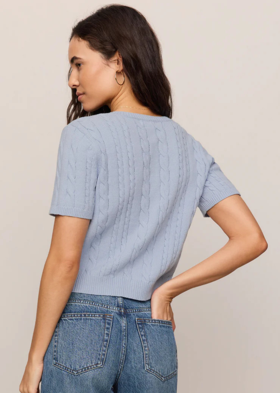 A short sleeve cardigan with cable knit detail and a soft structure.
