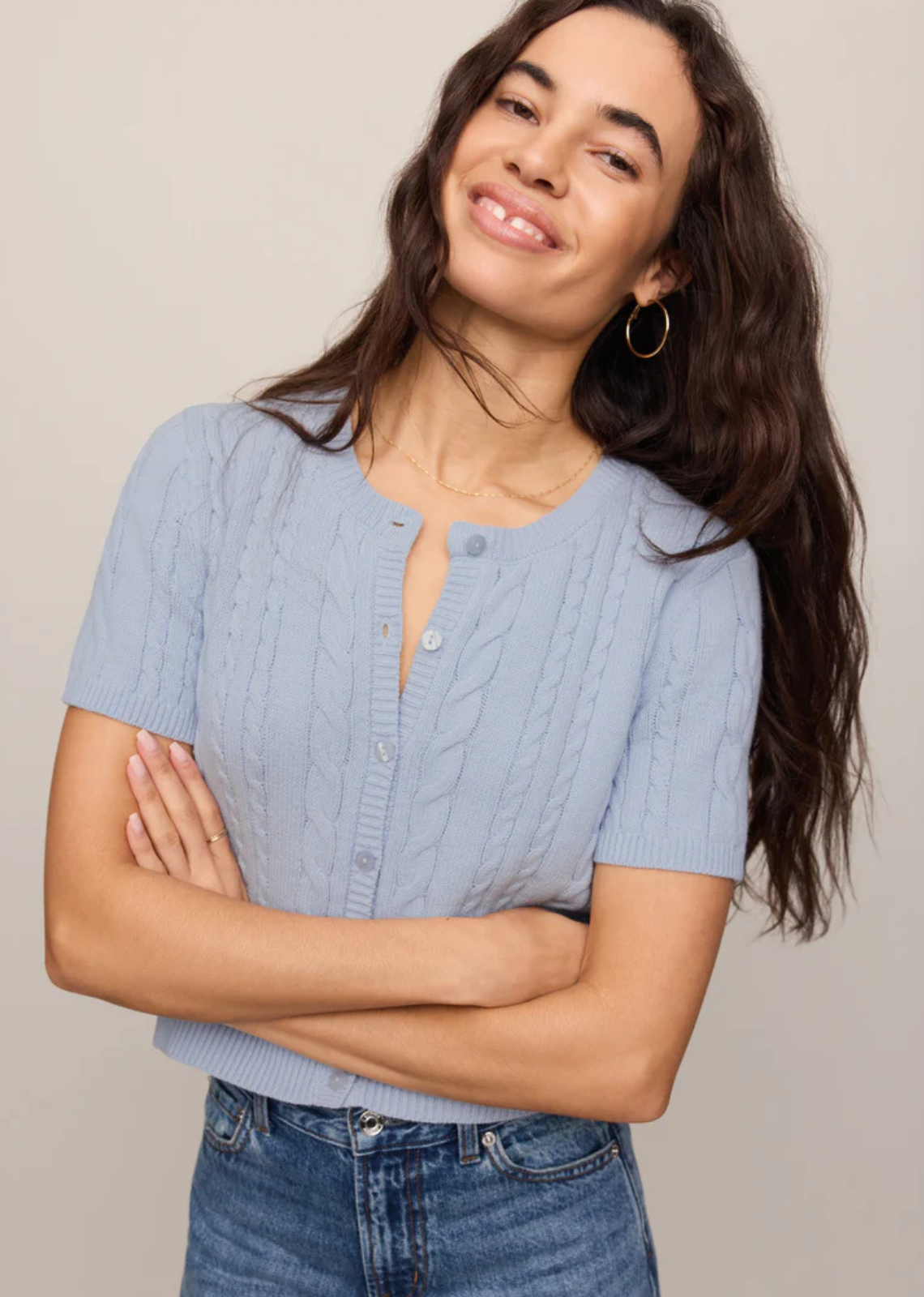 A short sleeve cardigan with cable knit detail and a soft structure.