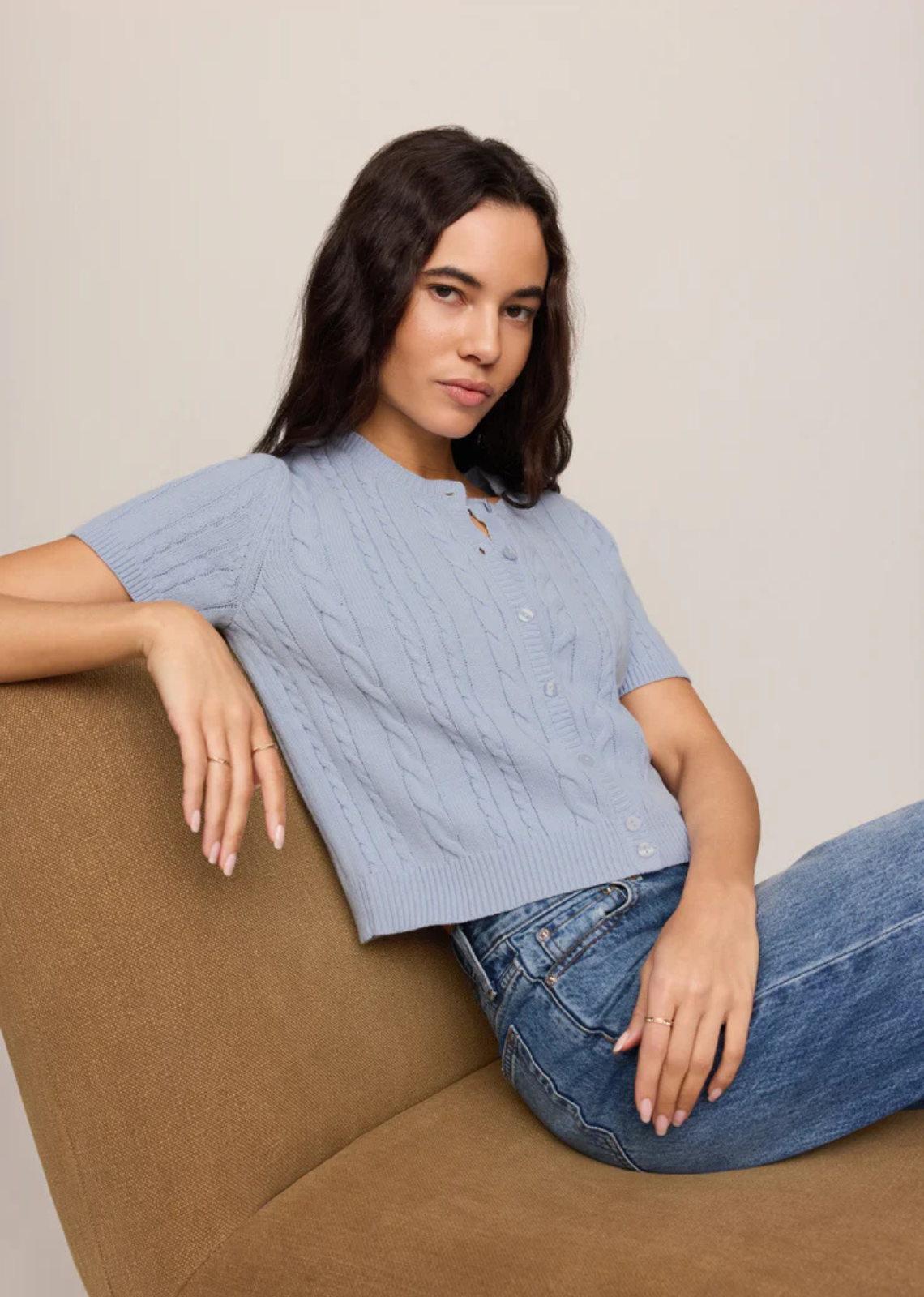 A short sleeve cardigan with cable knit detail and a soft structure.