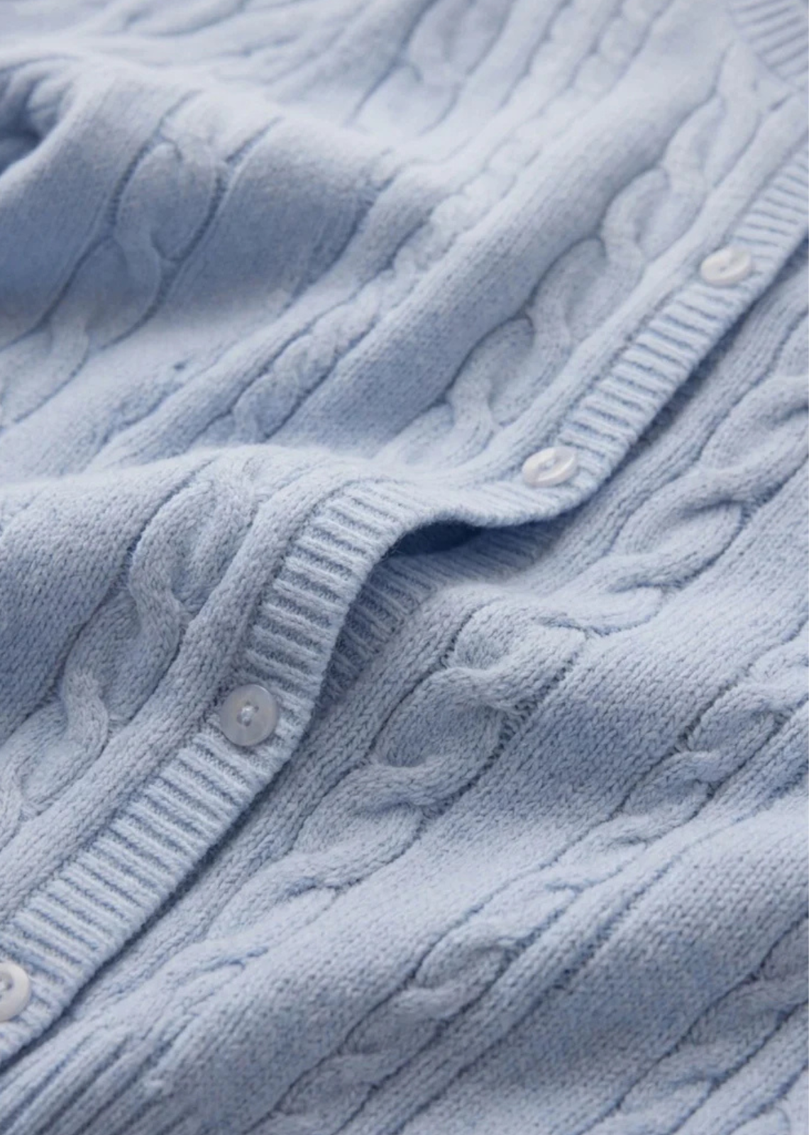 A short sleeve cardigan with cable knit detail and a soft structure.