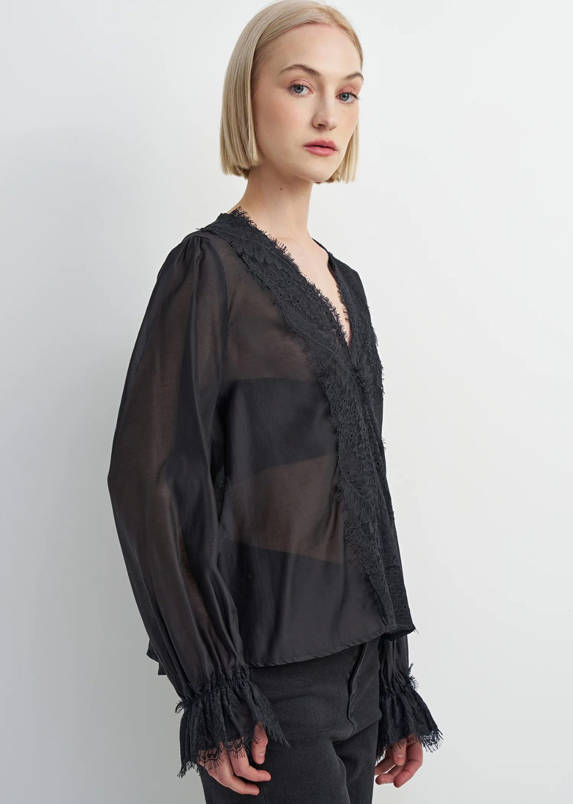 Black lyocell-blend blouse with soft draping, feminine detailing, and a flattering silhouette, designed with a subtle Western-inspired aesthetic.