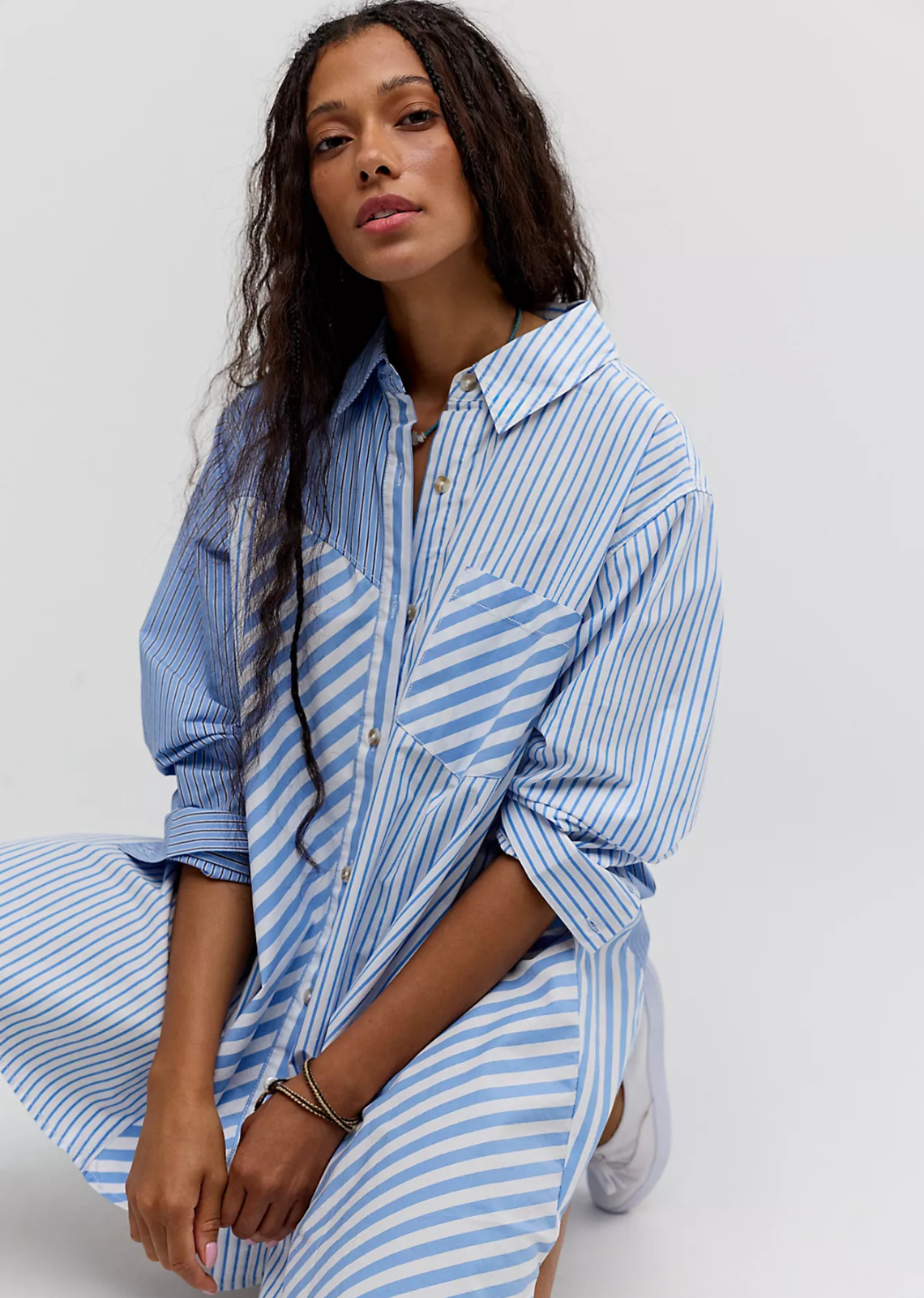 A classic cotton mini dress with a swingy A-line silhouette, collared neckline, long sleeves, contrasting panels, cuffed details, and a patch pocket at the bust.