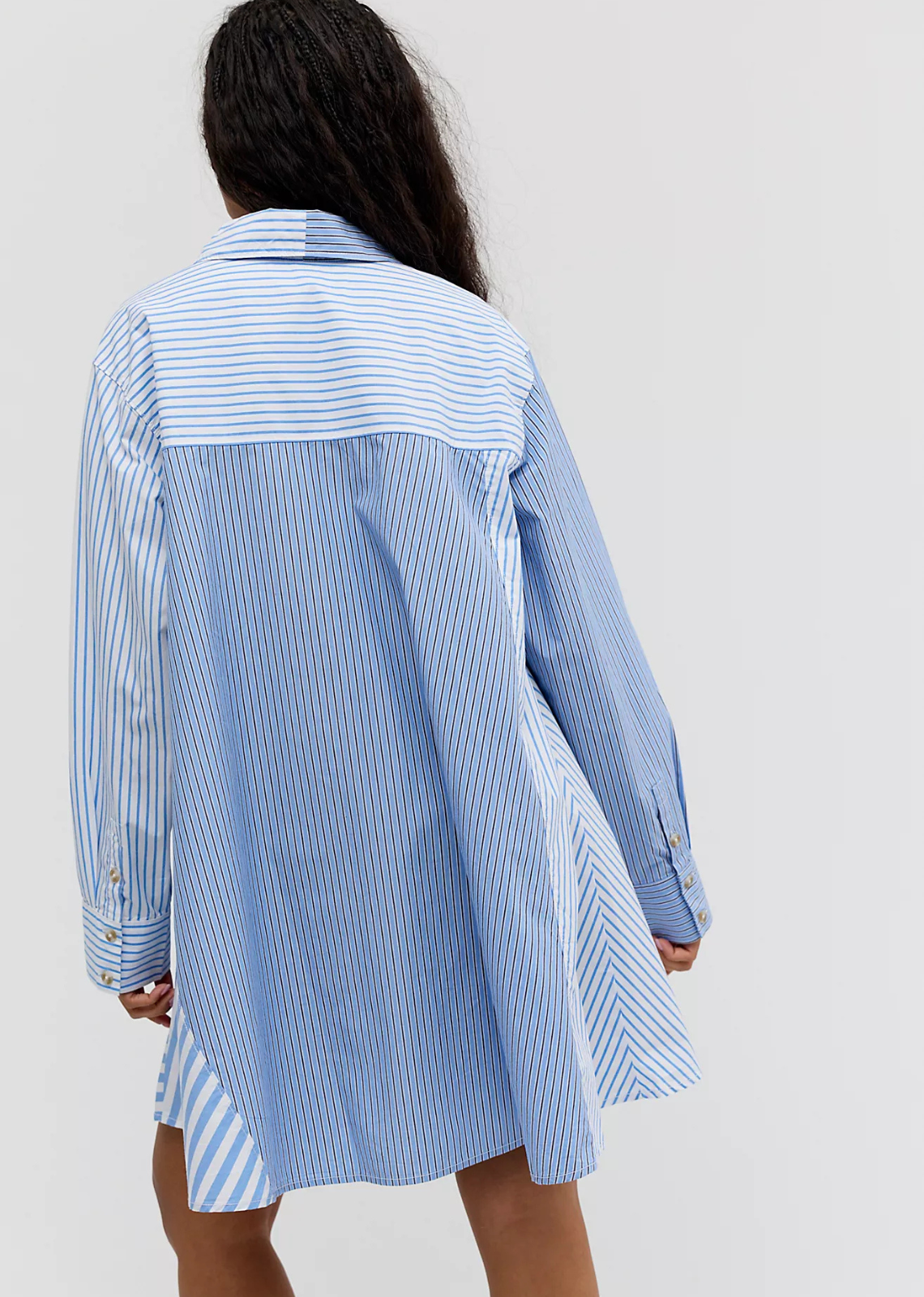 A classic cotton mini dress with a swingy A-line silhouette, collared neckline, long sleeves, contrasting panels, cuffed details, and a patch pocket at the bust.