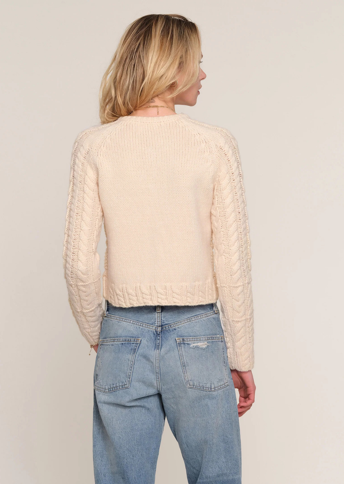 Soft melange knit cardigan with a relaxed fit, chunky cable-knit detailing, and button-down front with knit button loops.