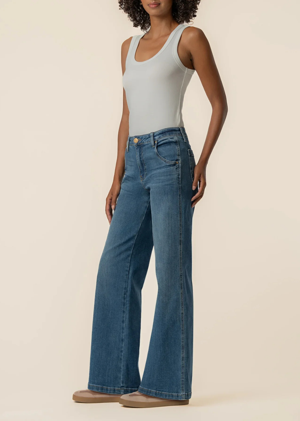 High-rise medium-wash wide-leg jeans featuring scoop pockets and stretch denim for a comfortable everyday fit.