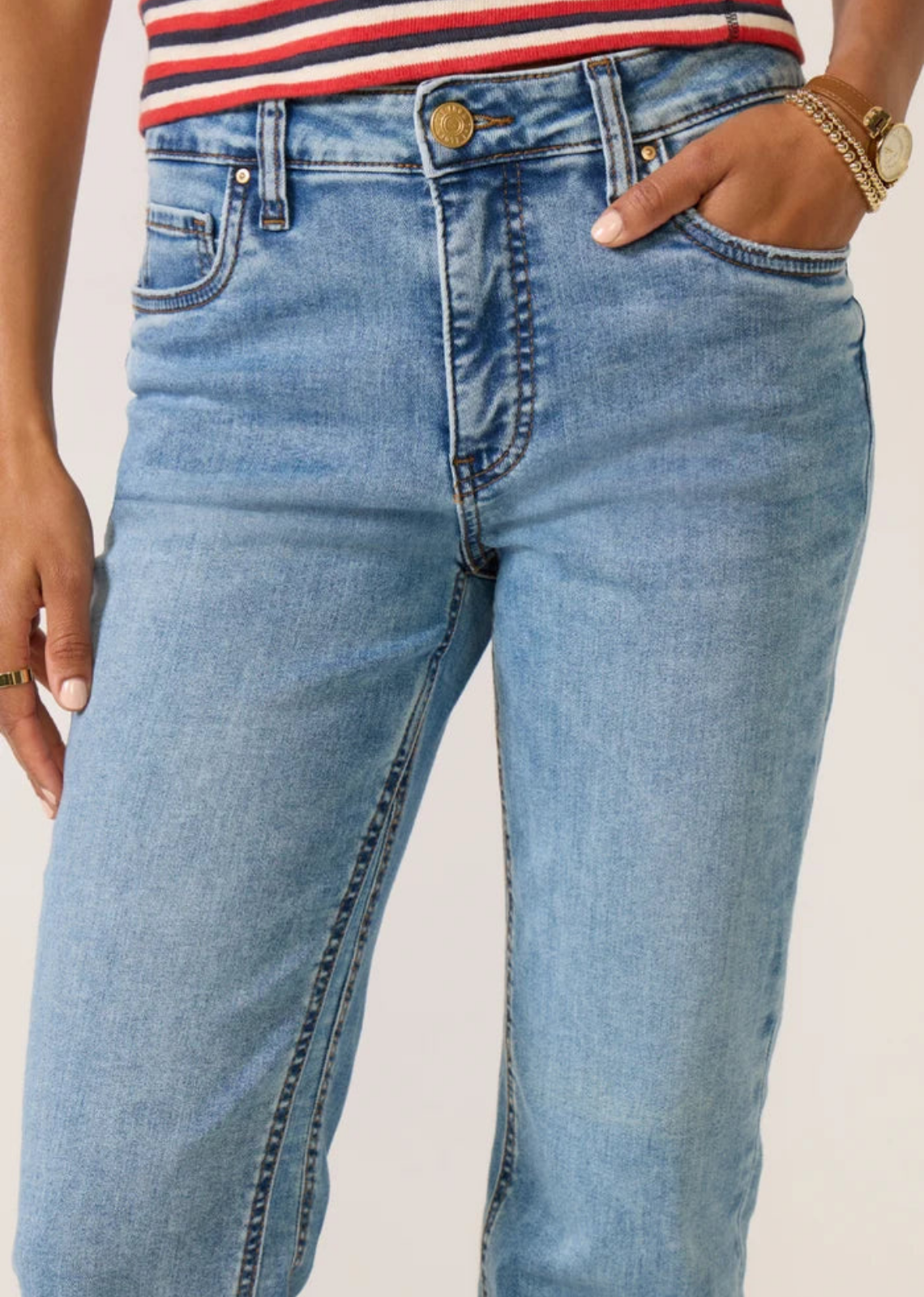 KUT from the Kloth Kelly high-rise flare jeans in a light-to-medium blue wash, featuring a slim fit, subtle flare, stretch denim, classic five-pocket styling, and raw-cut hems.
