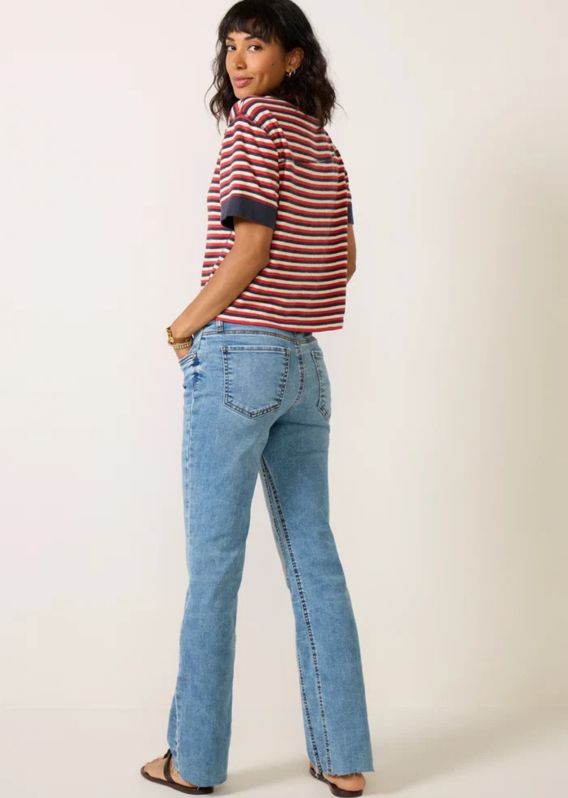 KUT from the Kloth Kelly high-rise flare jeans in a light-to-medium blue wash, featuring a slim fit, subtle flare, stretch denim, classic five-pocket styling, and raw-cut hems.
