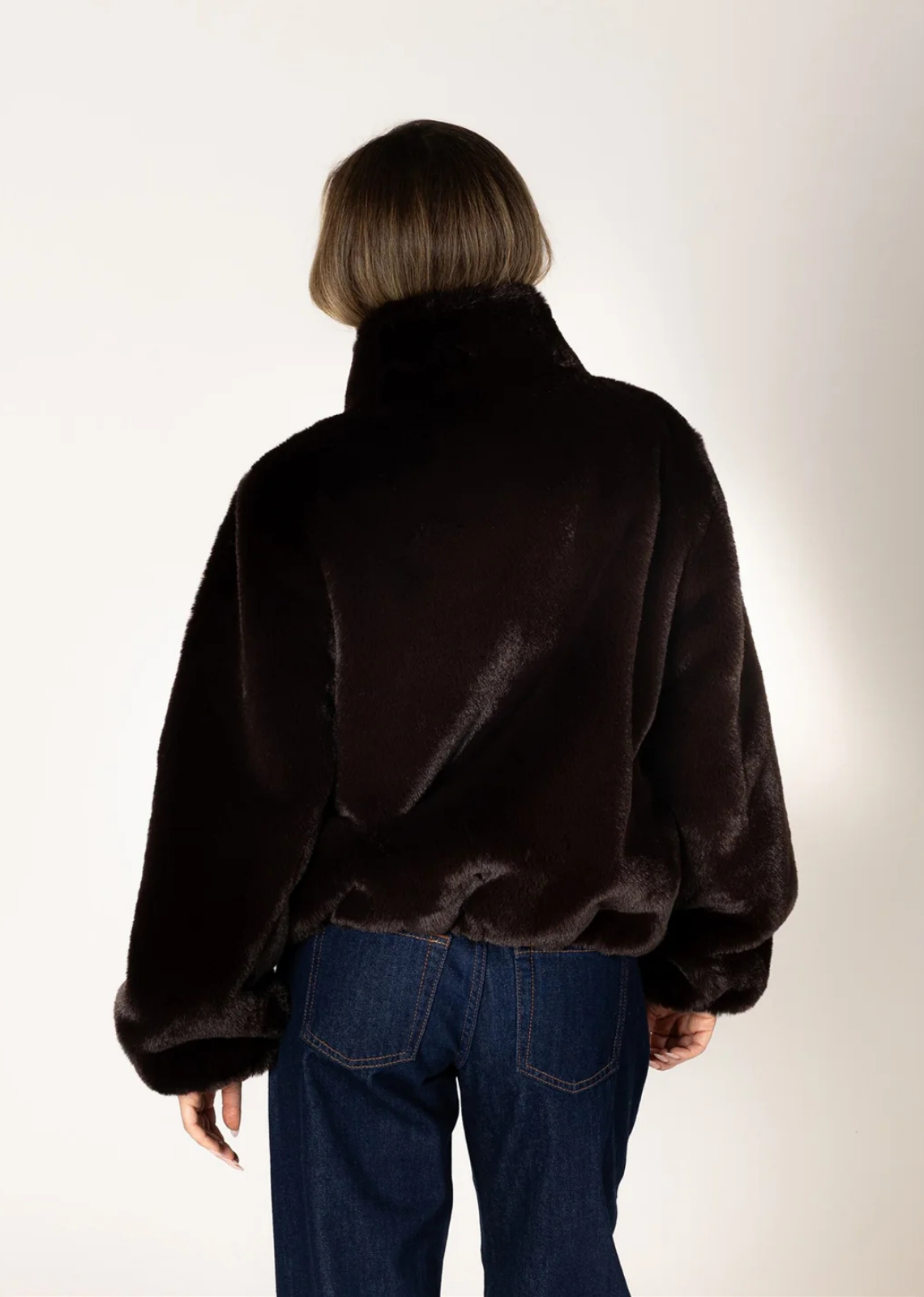 Rich espresso brown faux fur coat with a relaxed fit, long sleeves, crew neckline, and front button closure.