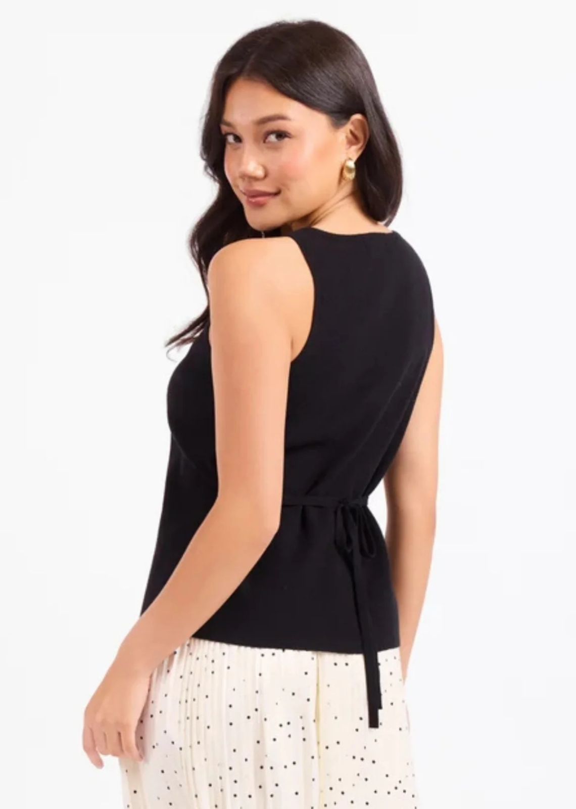 Black sleeveless knit sweater waistcoat featuring a crew neckline, tortoiseshell-style button front, split hem, and adjustable back tie belt.