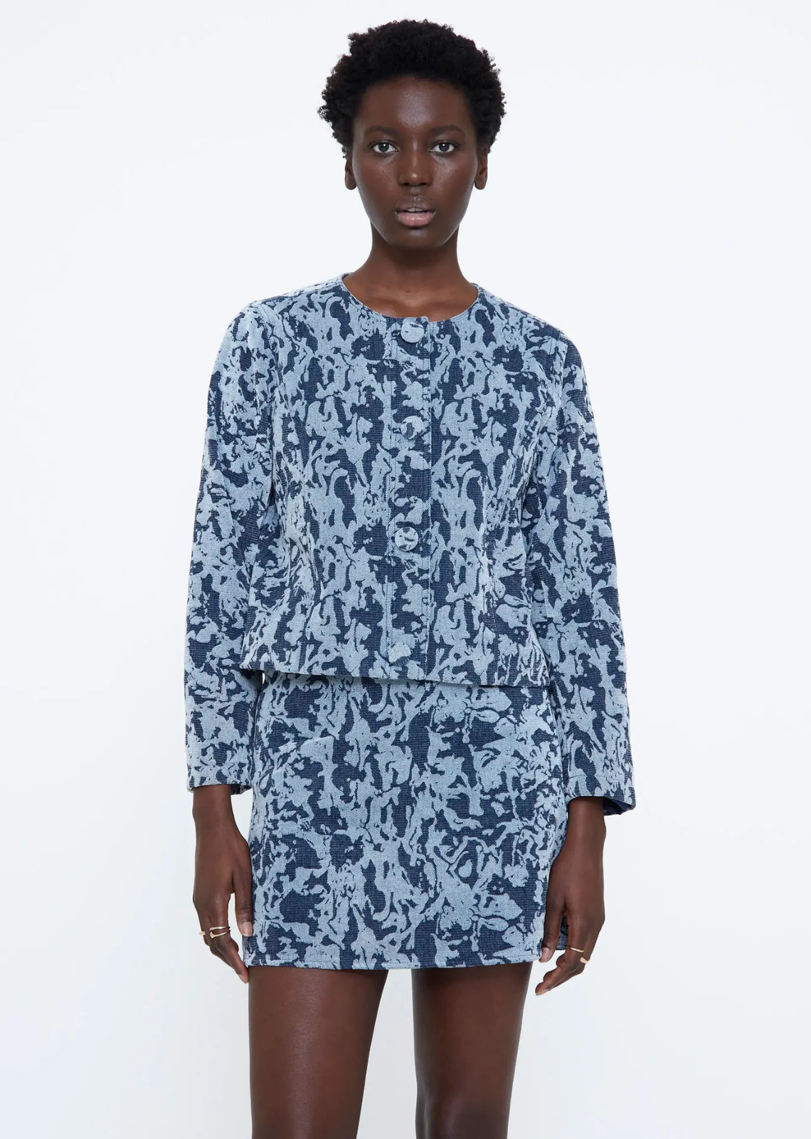 Navy blue jacquard knit jacket with a round neckline, long sleeves, front button closure, and lined interior.
