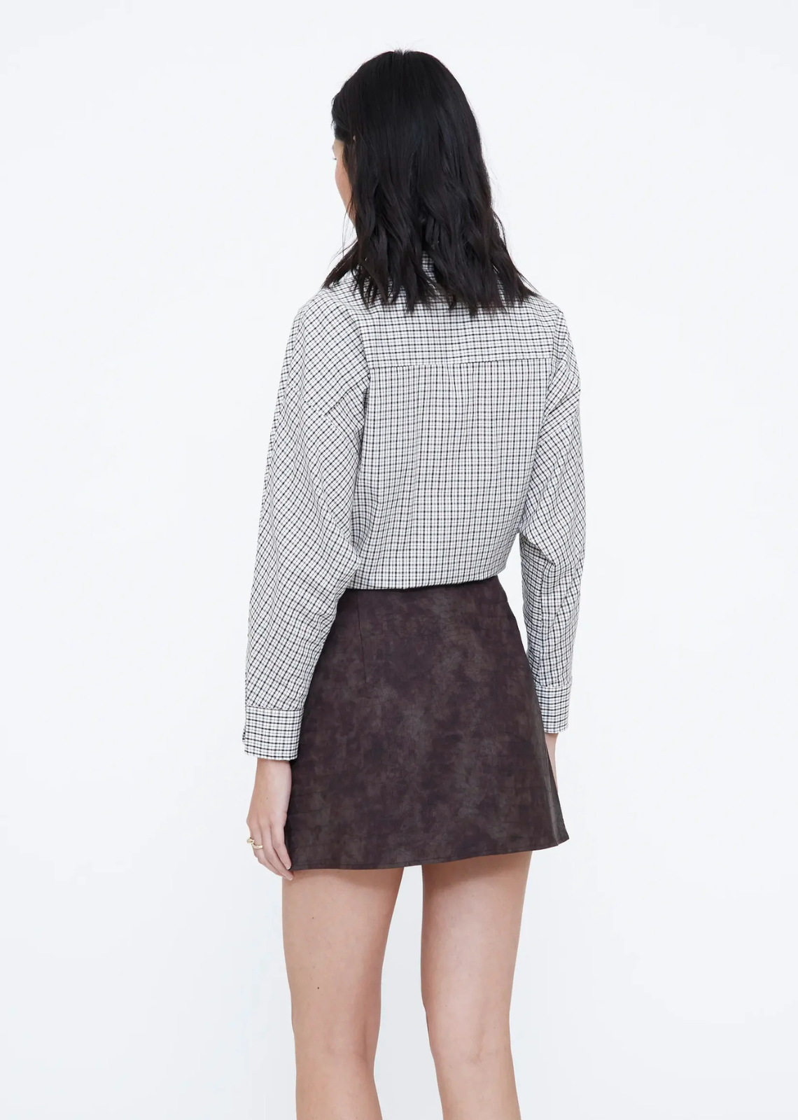 Brown faux leather mini skirt with a fixed Brown faux leather mini skirt with a fixed mid-rise waistband and side zip fastening.