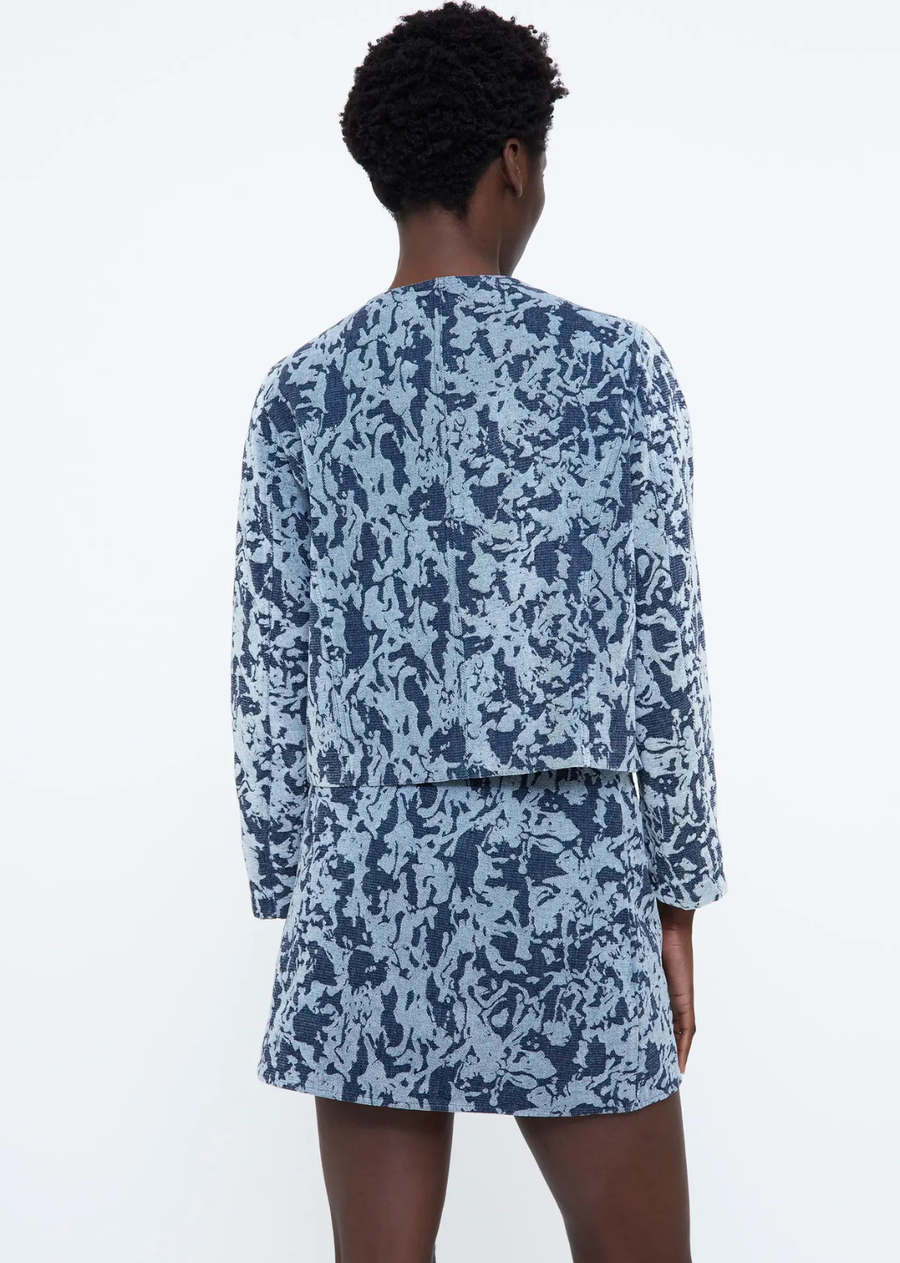 Navy blue jacquard knit jacket with a round neckline, long sleeves, front button closure, and lined interior.