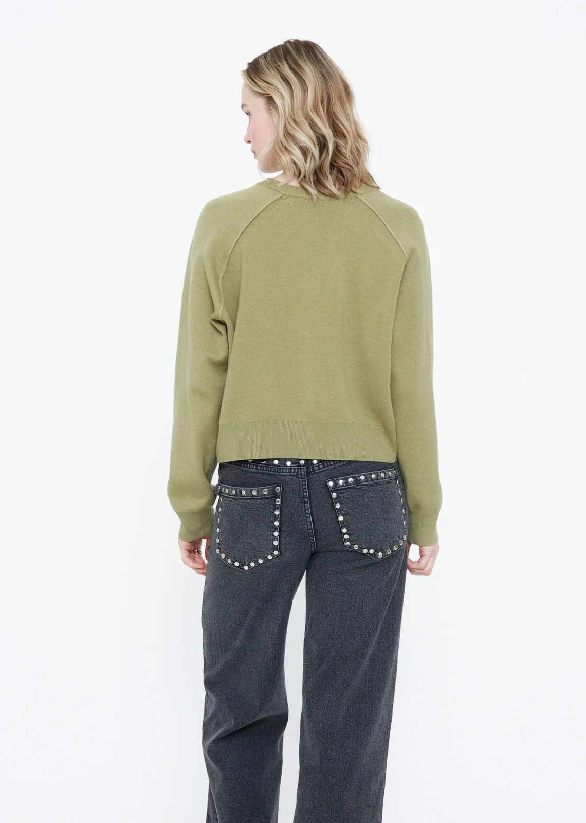 Green knit cardigan with a round neckline, long sleeves, dropped shoulders, matching green buttons, and ribbed trims.